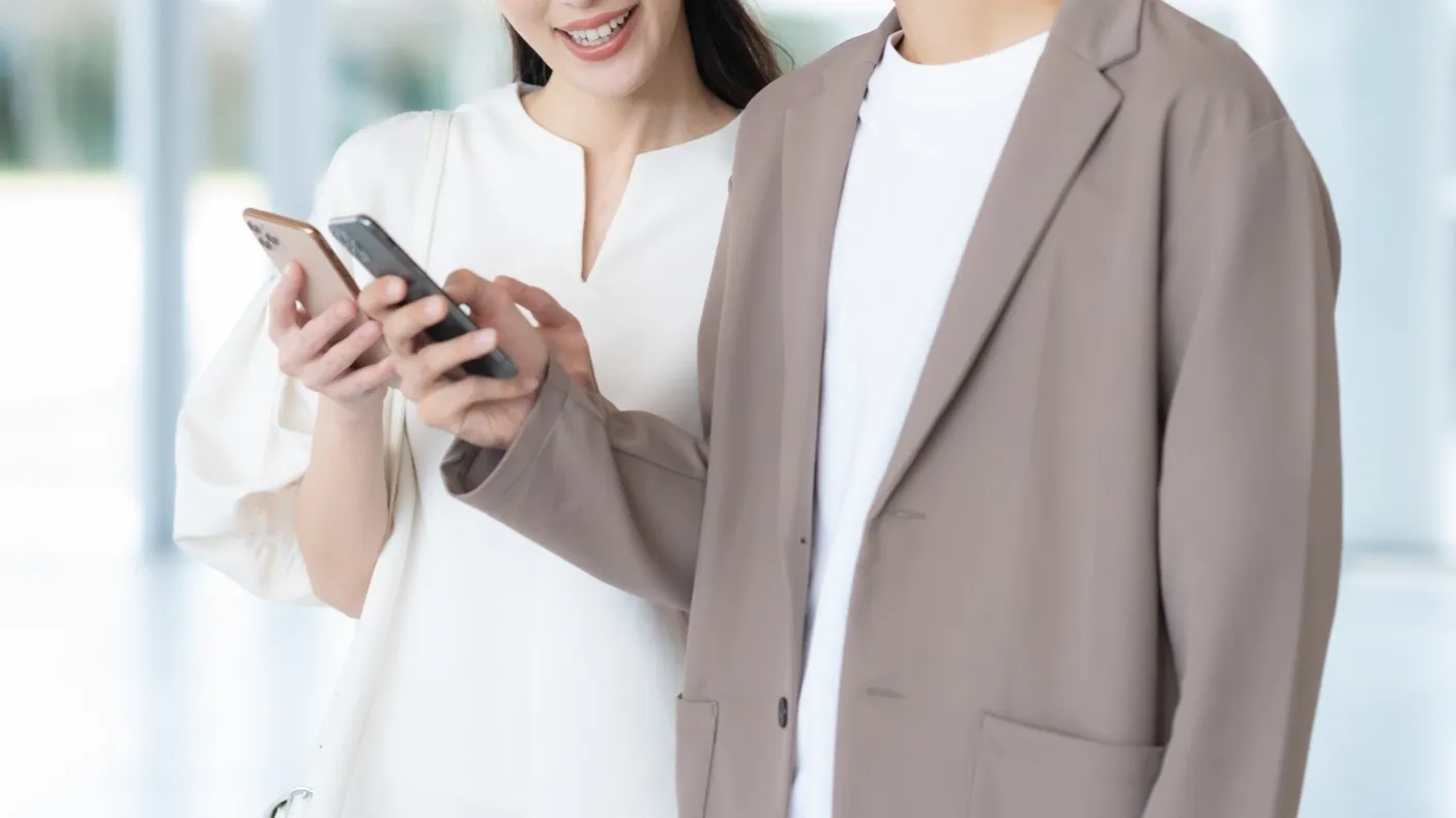 スマホを確認し合うカップル